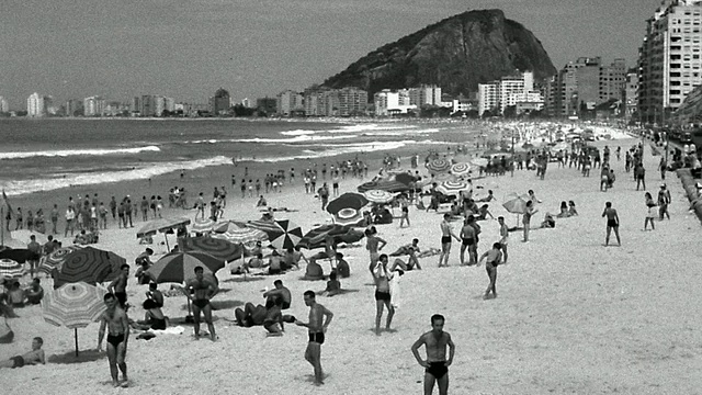 B/W高角度广角拍摄PAN海滩场景与人群，雨伞+建筑物/里约热内卢De Janeiro，巴西视频素材