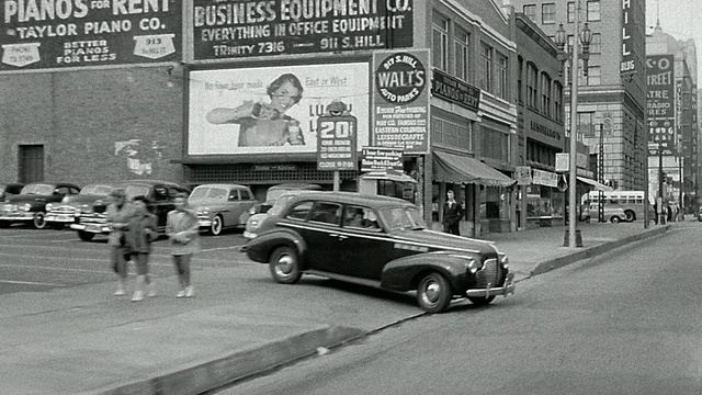 1950年，后方汽车视角行驶在街道上经过商店+停车场/洛杉矶视频素材