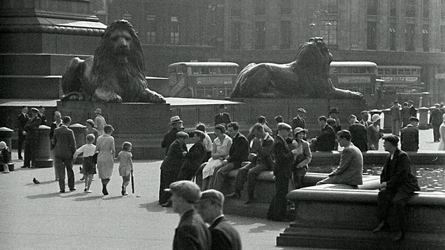 1920年代的B/W宽拍摄人们坐在+走过特拉法加广场，背景是狮子雕像/伦敦视频素材