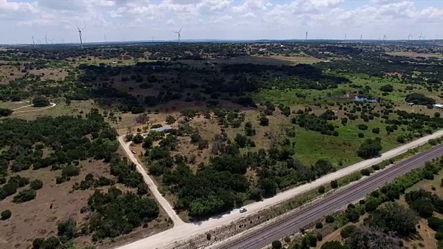 航拍:沿着土路走，德克萨斯丘陵乡村牧场和风力发电场视频素材