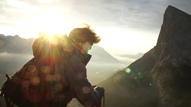 登山者在悬崖边卷绳子，然后把它扔到下面视频素材