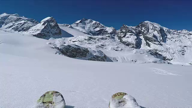 在冰川或群山环绕的新雪上滑雪视频素材