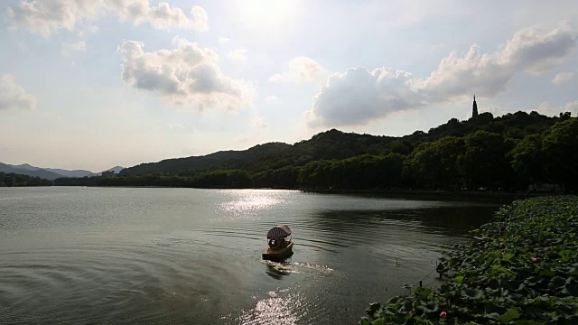 中国杭州，小船在西湖上航行，背靠宝塔的剪影视频素材