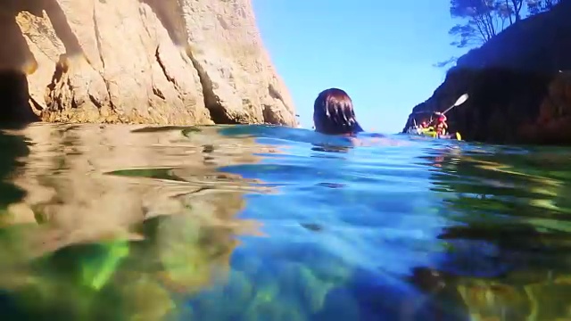 夏天，女孩在地中海的布拉瓦海岸游泳，在一个田园诗般的地方与自然拱门的水下风景。视频素材