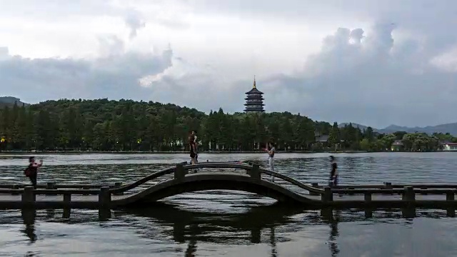 从白天到夜晚4K延时:人们沿着石桥上的雷峰塔，杭州，中国视频素材