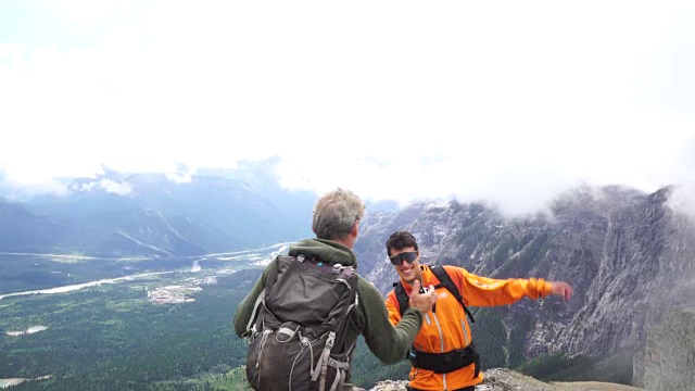 成熟和年轻的登山家攀登山脊，雾天视频素材