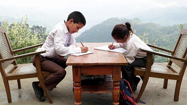 学校的孩子们在家里做作业，喜马拉雅山在后面的背景视频素材