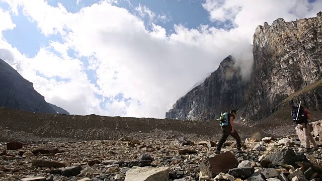 徒步旅行者通过冰碛上升到上面的山峰视频素材