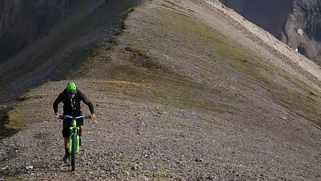 山地自行车穿过高高的山脊，下面是山谷视频素材