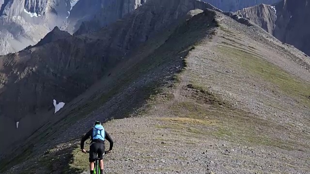 山地自行车穿过高高的山脊，下面是山谷视频素材