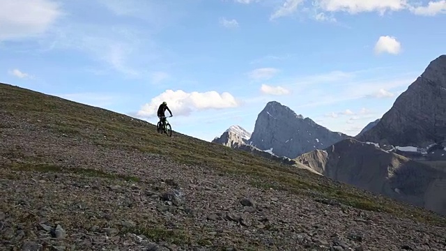 山地自行车穿过高高的山脊，下面是山谷视频素材