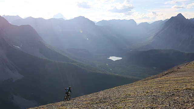 山地自行车穿过高高的山脊，下面是山谷视频素材