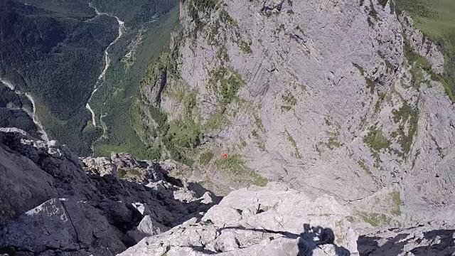 飞行服飞行员从悬崖上跳下，飞越山谷视频素材