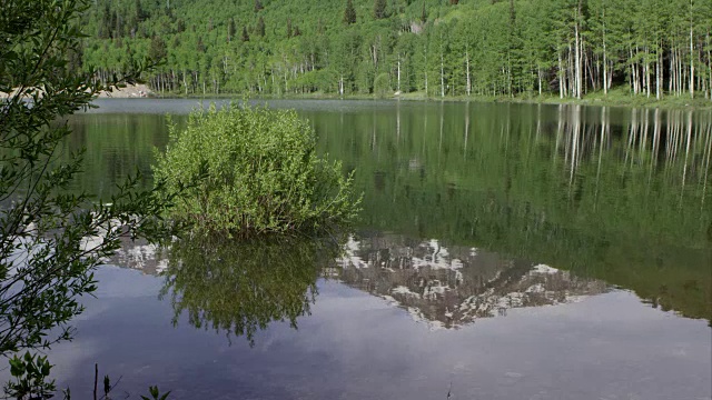 湖水倒映着山，背景是森林。视频素材