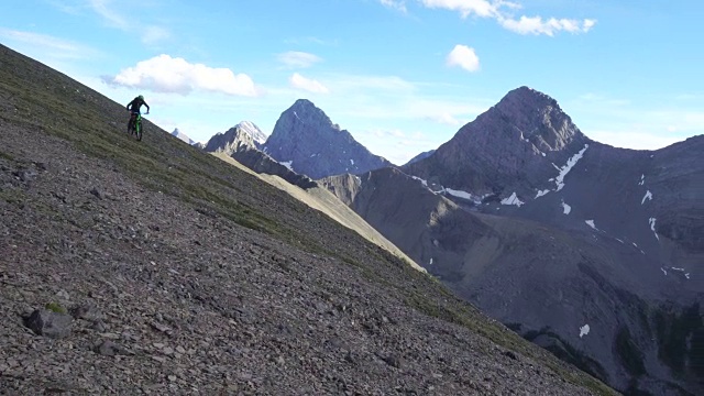 一个年轻人沿着山脊骑着他的山地车视频素材