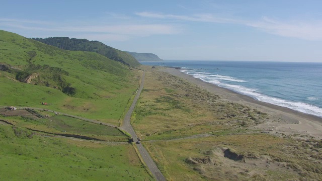 WS TD AERIAL POV Green Hill和汽车在失落海岸的道路上，加利福尼亚视频素材