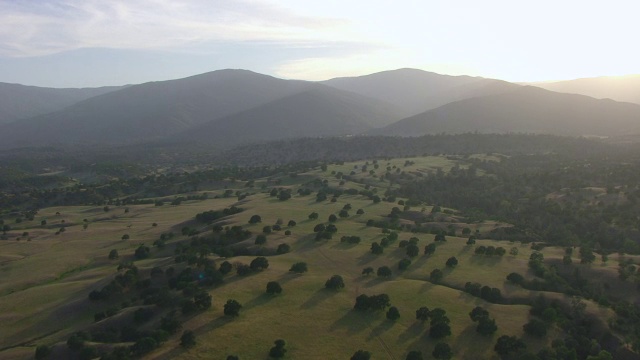 WS AERIAL POV绿色景观与剪影山在日落在门多西诺国家森林，加利福尼亚州视频素材