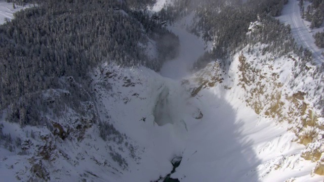 美国黄石公园，大雪覆盖的Lower Falls上空的空中轨道视频素材