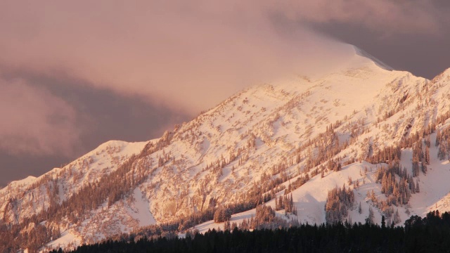 雪山在晨曦中闪耀着红光。视频素材