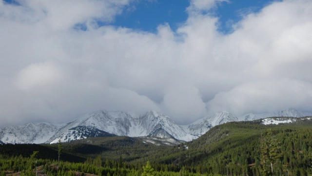 乌云在山峦和绿树成荫的山坡上翻腾。视频素材