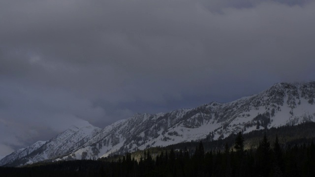 黎明时分，乌云在白雪覆盖的山上翻腾。视频素材