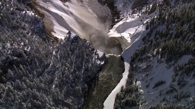 美国黄石公园，大雪覆盖的黄石瀑布上空的空中轨道视频素材