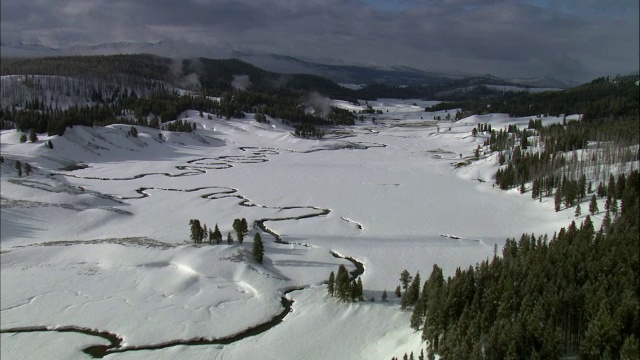 美国黄石公园，雪景中蜿蜒河流上的空中轨道视频素材