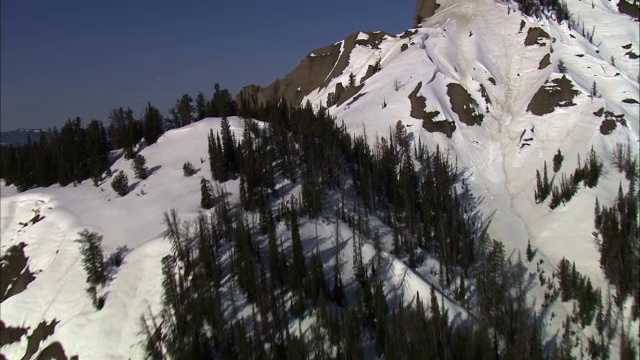 美国黄石国家公园积雪覆盖的山脊上的空中轨道视频素材