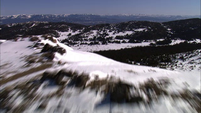 美国黄石国家公园，从积雪覆盖的山脊到山谷的空中轨道视频素材