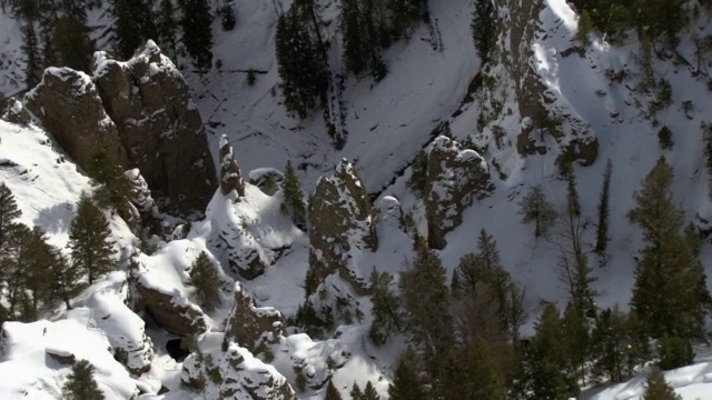 美国黄石国家公园，在被雪覆盖的岩石尖塔上的空中轨道视频素材