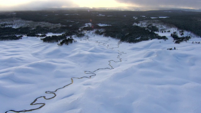 美国黄石公园，雪景中蜿蜒河流上的空中轨道视频素材