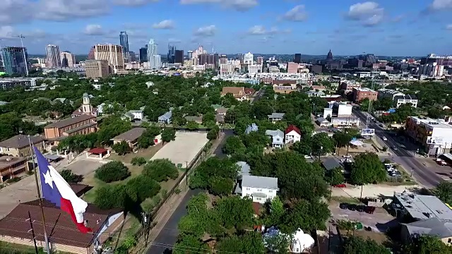 航拍:在德克萨斯首府奥斯汀市上空，悬挂着德克萨斯国旗，城市背景为霜冻银行塔和奥斯汀视频素材