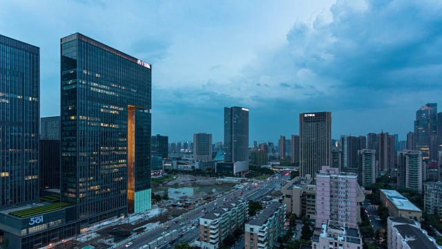 从白天到夜晚的4K延时:中国杭州，交通在城市道路周围的建筑物上移动的夜景视频素材