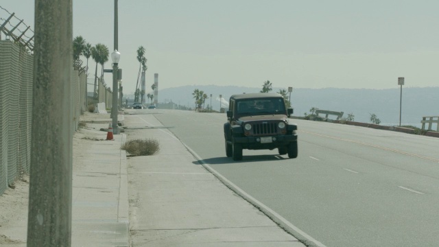 沿海岸道路行驶的汽车的中等角度。视频素材