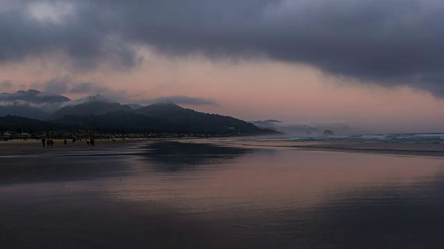 移动的云和天空的时间流逝与人们享受自己沿太平洋在Cannon海滩低潮日落到傍晚视频素材