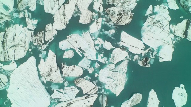 空中飞过JÃ¶kulsÃ±³冰川泻湖直接向下看，在冰岛急剧缩小视频素材