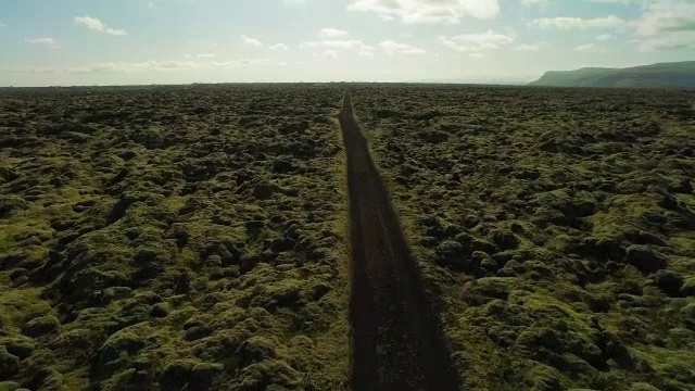 空中飞过苔藓覆盖的熔岩岩石在冰岛沿着道路视频素材