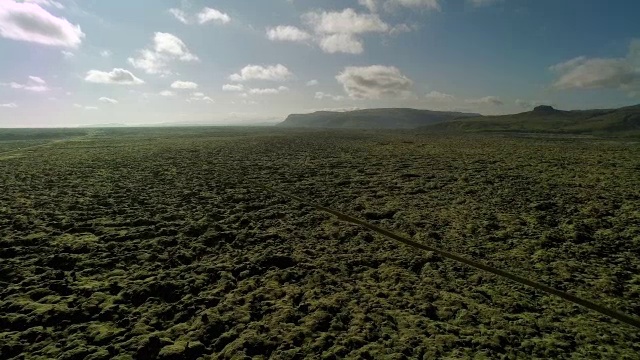 空中飞过苔藓覆盖的熔岩岩石在冰岛沿着道路视频素材