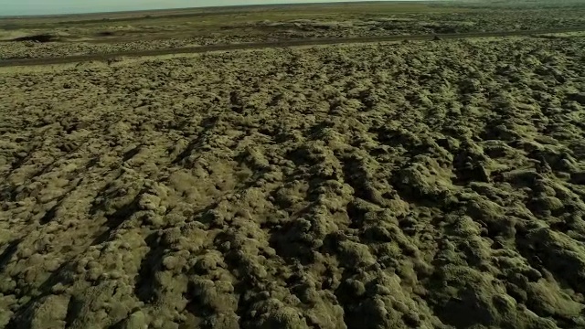 空中飞过覆盖着苔藓的熔岩岩石，经过冰岛的公路视频素材