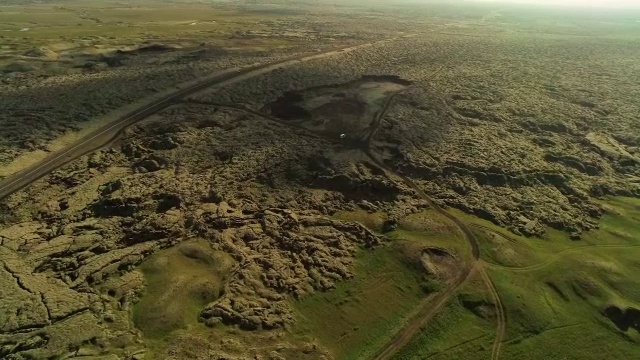 空中飞过苔藓覆盖的熔岩岩石，沿着公路在冰岛视频素材