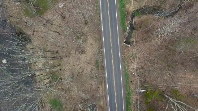 在纽约北部与河流平行的空的单车道道路的鸟瞰图视频素材