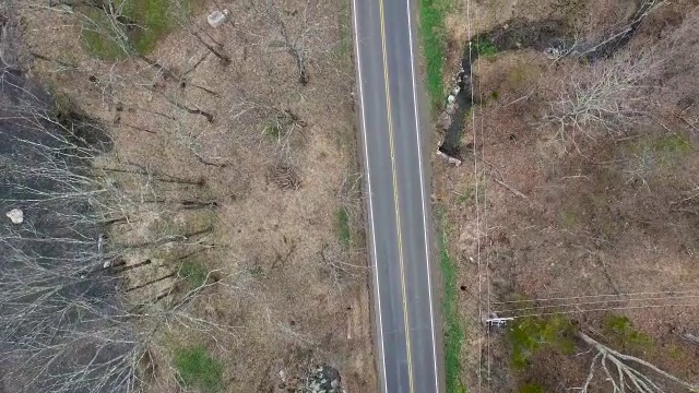 在纽约北部与河流平行的空的单车道道路的鸟瞰图视频素材