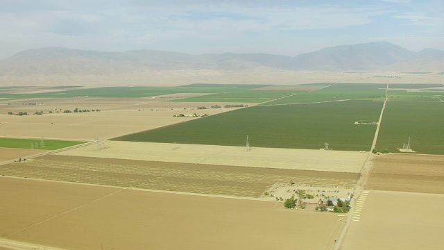 WS PAN AERIAL POV在San Joaquin山谷的绿色农田，在背景山/加利福尼亚，美国视频素材