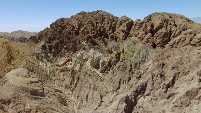 WS AERIAL POV沙漠山谷中的沙质岩石丘陵和岩石顶峰，有耕地，索尔顿海与远处的山脉接壤/美国加州视频素材