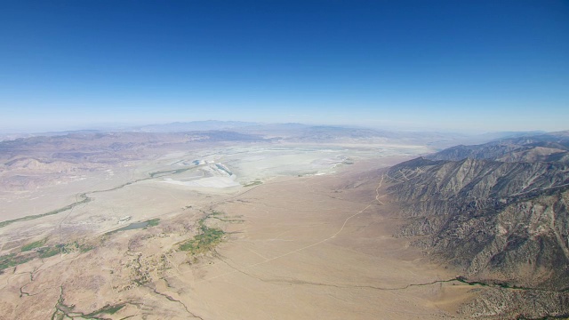 WS AERIAL POV视图欧文斯谷与内华达山脉丘陵的干燥欧文斯湖床，在背景/美国加州视频素材