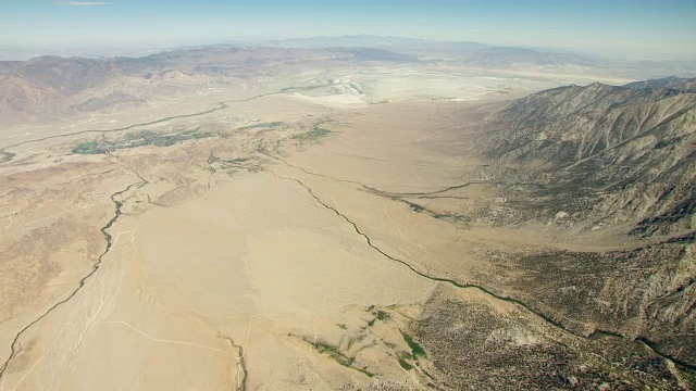 WS AERIAL POV视图欧文斯谷与内华达山脉丘陵的干燥欧文斯湖床，在背景/美国加州视频素材