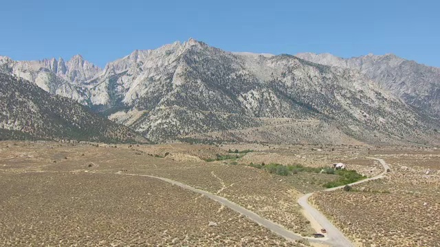 WS AERIAL POV Whitney Portal Road蜿蜒穿过Sierra Nevada的沙漠山谷，背景是山脉/美国加州视频素材