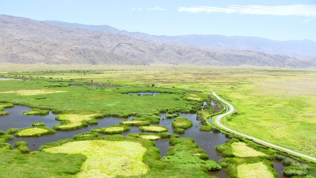 WS AERIAL POV沼泽在欧文斯谷沙漠与滚动的山麓，Inyo山在背景/美国加州视频素材