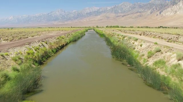 WS TU AERIAL POV视图欧文斯河与洛杉矶渡槽连接沙漠山谷，内华达山脉因约山的背景/美国加州视频素材