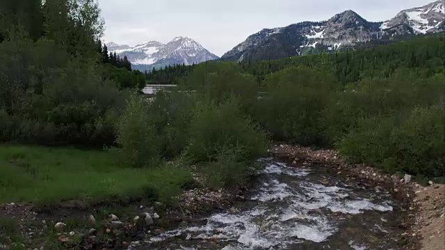 上升鸟瞰河显示湖泊和山脉。视频素材